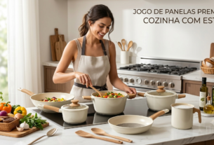 Mulher sorridente cozinhando legumes em um jogo de panelas bege e cabo de madeira em cozinha moderna.