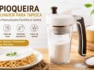 Dois modelos de tapioqueira polvilhador para tapioca feitos de inox e vidro com goma de mandioca dentro, posicionados em uma bancada de cozinha iluminada ao lado da caixa do produto e de uma tigela com bananas e manga picadas