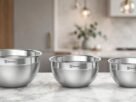Kit Electrolux com três tigelas de aço inoxidável de diferentes tamanhos, dispostas sobre uma bancada de mármore em uma cozinha moderna.