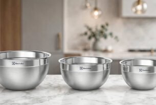 Kit Electrolux com três tigelas de aço inoxidável de diferentes tamanhos, dispostas sobre uma bancada de mármore em uma cozinha moderna.